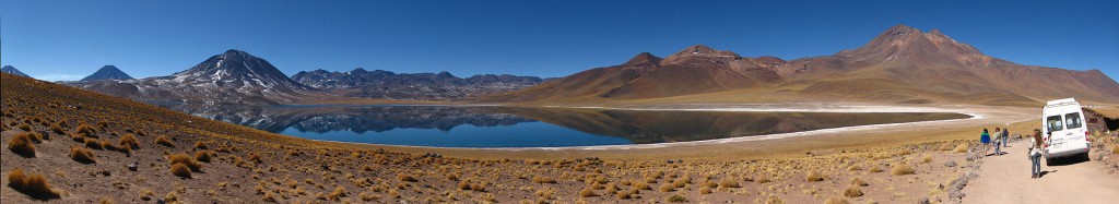 Veículo turístico estacionado ao lado de lagoas serranas no Atacama