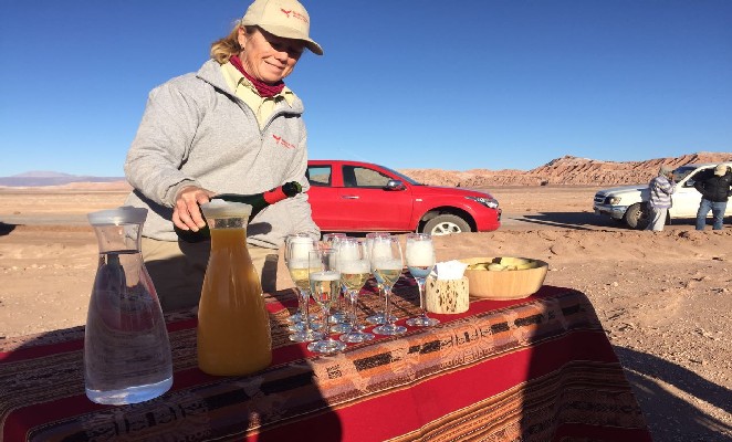 Mulher derramando champanhe no deserto de Atacama