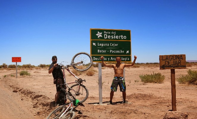 Viajante segura bicicleta nas estradas do deserto de Atacama