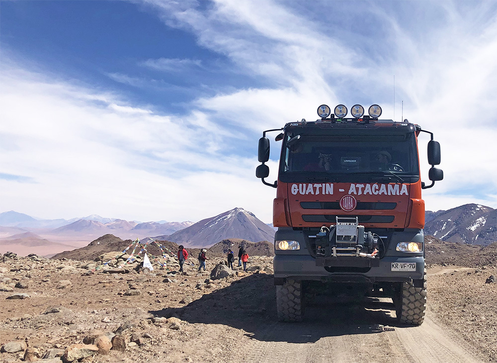 Caminhão em frente aos vulcões no Atacama